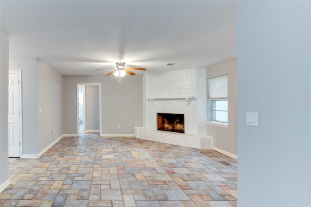 unfurnished living room featuring a fireplace and ceiling fan