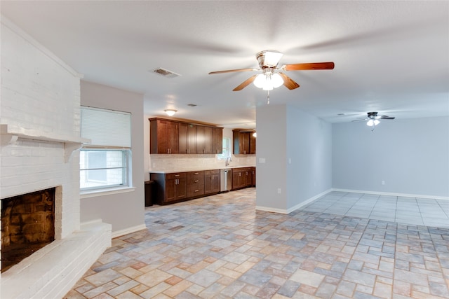 unfurnished living room with sink, ceiling fan, and a brick fireplace