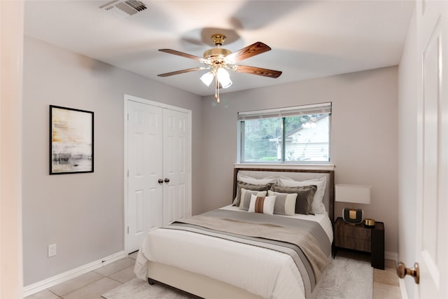 tiled bedroom with ceiling fan and a closet