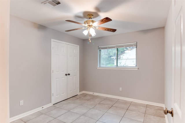 unfurnished room with ceiling fan and light tile patterned floors