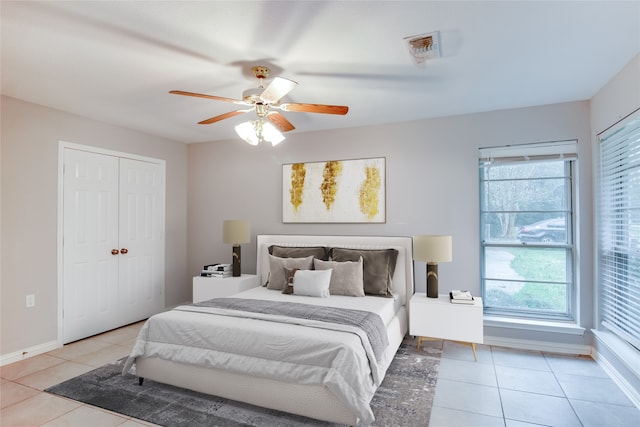 tiled bedroom featuring a closet, multiple windows, and ceiling fan