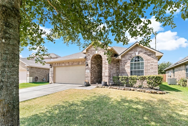 view of front of home with a front yard, central air condition unit, and a garage