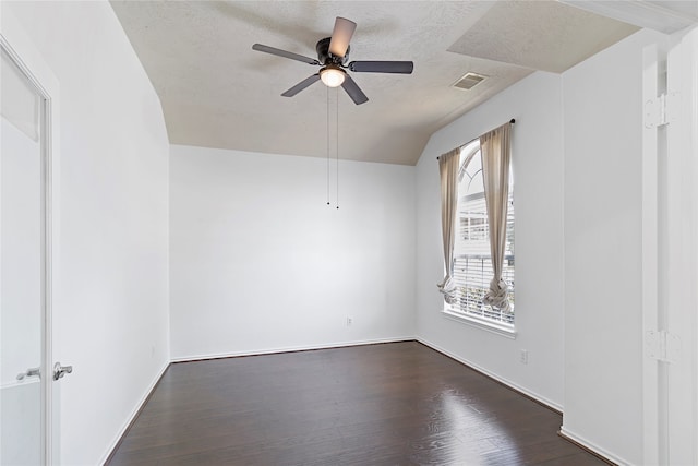 spare room featuring ceiling fan, vaulted ceiling, a textured ceiling, and dark hardwood / wood-style flooring