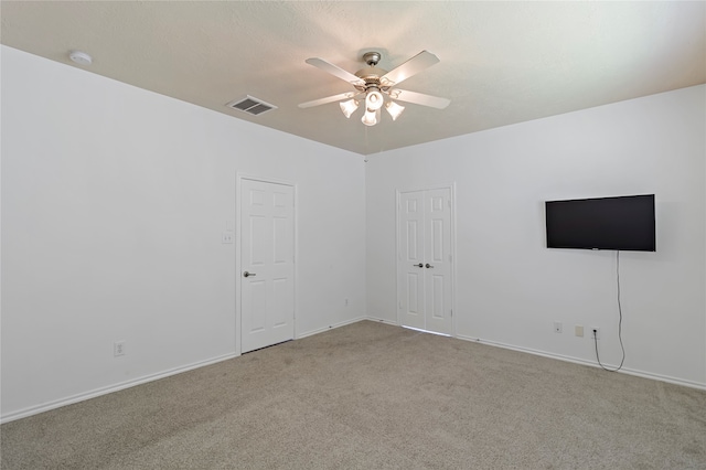 carpeted empty room featuring ceiling fan