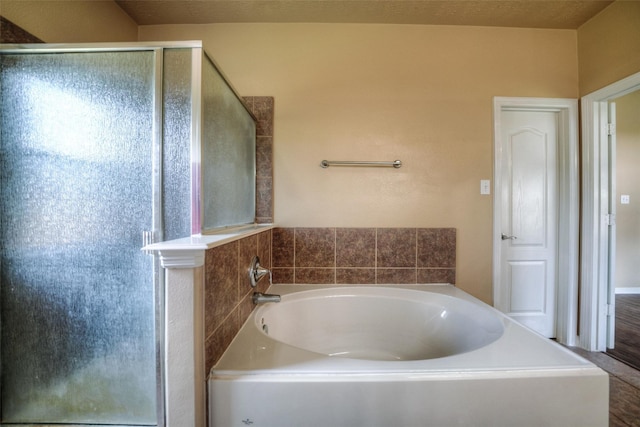 bathroom featuring a textured ceiling, separate shower and tub, and hardwood / wood-style flooring