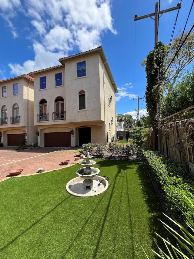 back of property with a garage and a yard