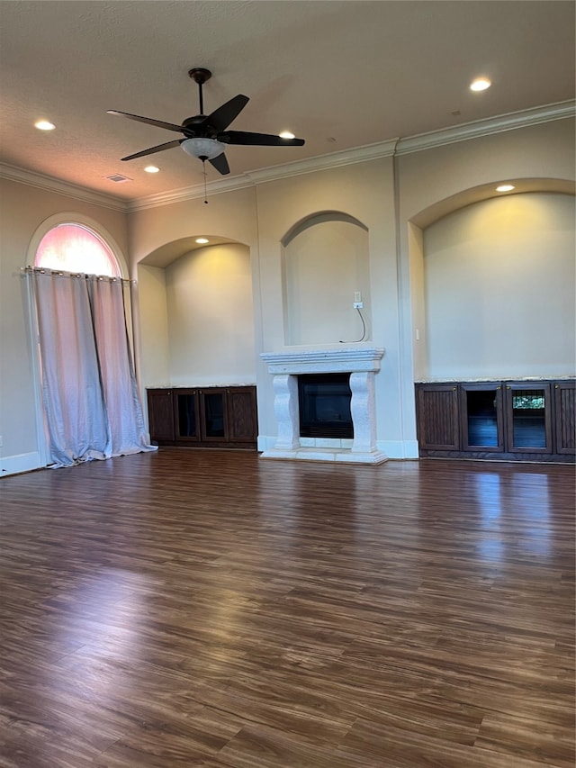 unfurnished living room featuring ceiling fan, crown molding, and dark wood-type flooring