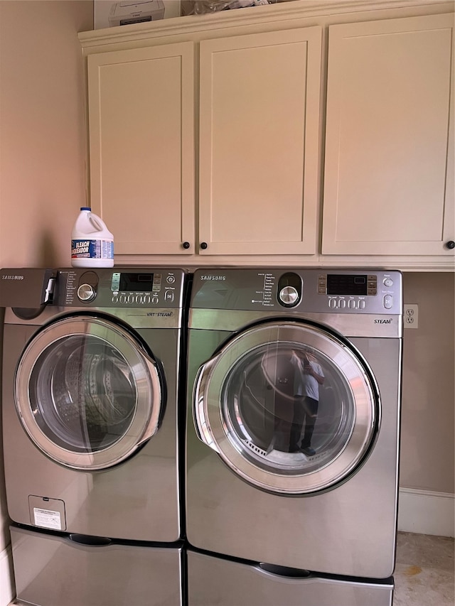 laundry area featuring washer and clothes dryer and cabinets