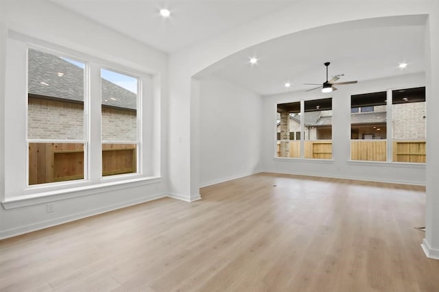 unfurnished living room with light hardwood / wood-style floors, ceiling fan, and a healthy amount of sunlight