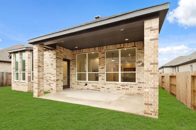 rear view of property featuring a yard and a patio area