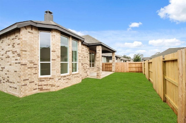 back of property featuring a lawn and a patio