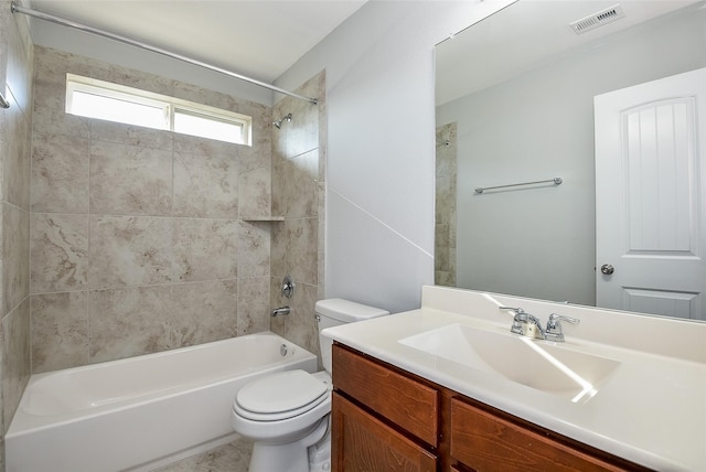 full bathroom featuring vanity, tiled shower / bath combo, and toilet