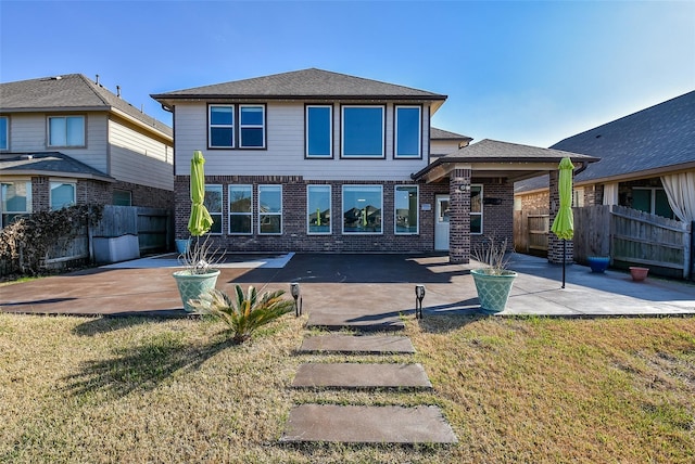 back of property with a patio and a lawn