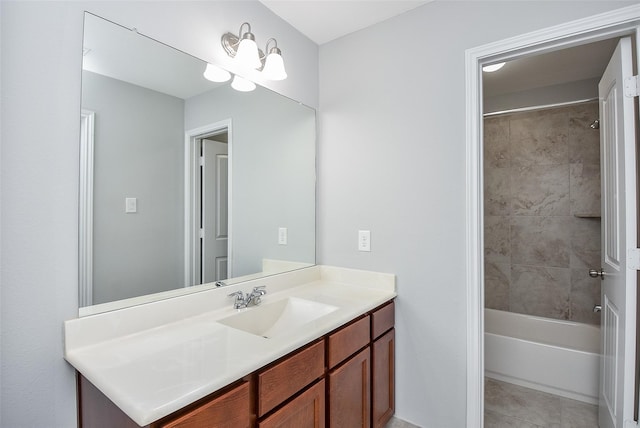 bathroom featuring tile patterned flooring, tiled shower / bath, and vanity