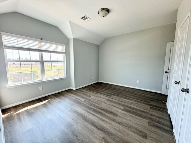 unfurnished bedroom featuring dark hardwood / wood-style floors and vaulted ceiling