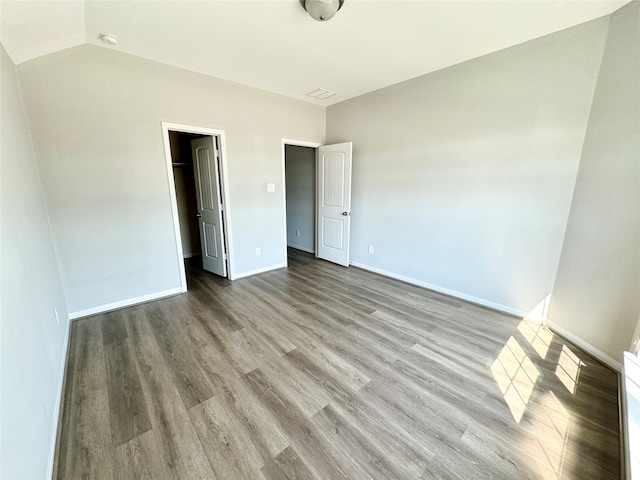 unfurnished bedroom featuring a spacious closet and light hardwood / wood-style flooring