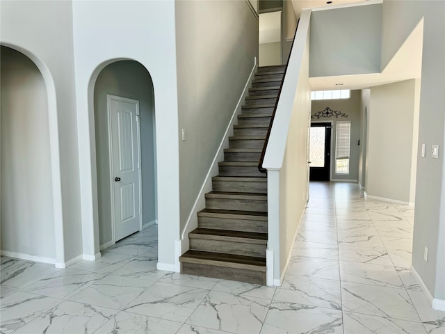 stairway featuring a towering ceiling