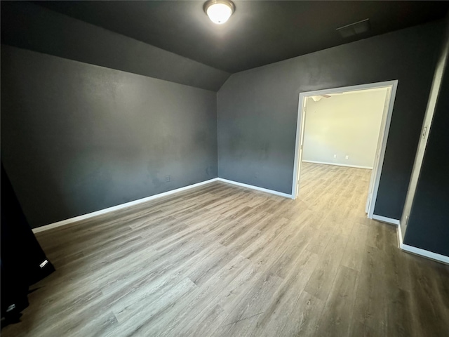 additional living space featuring lofted ceiling and light hardwood / wood-style floors