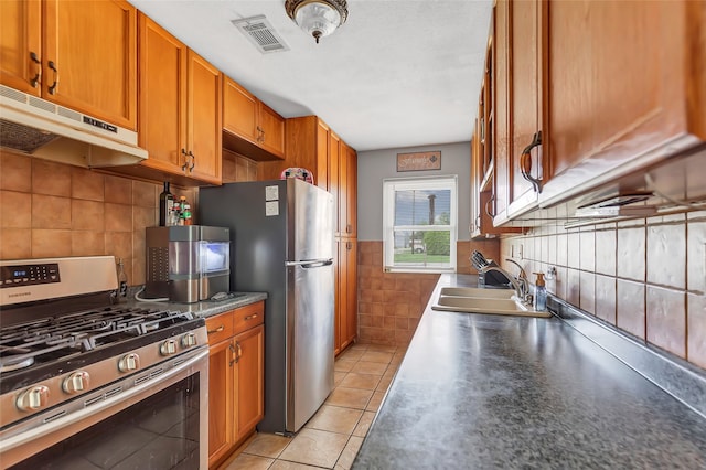 kitchen with light tile patterned flooring, appliances with stainless steel finishes, and sink