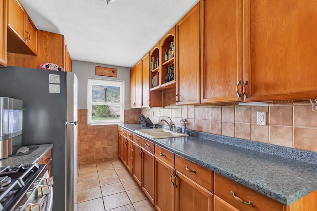 kitchen with light tile patterned floors, stainless steel appliances, backsplash, and sink