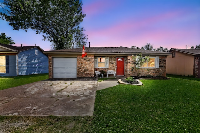 ranch-style home featuring a lawn and a garage