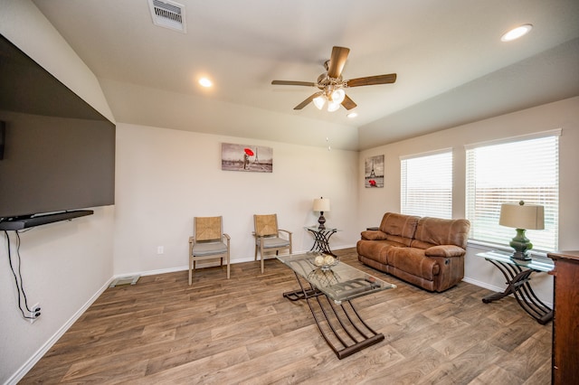 living room featuring ceiling fan, lofted ceiling, and light hardwood / wood-style flooring