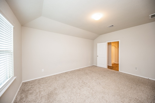 spare room with lofted ceiling and carpet flooring