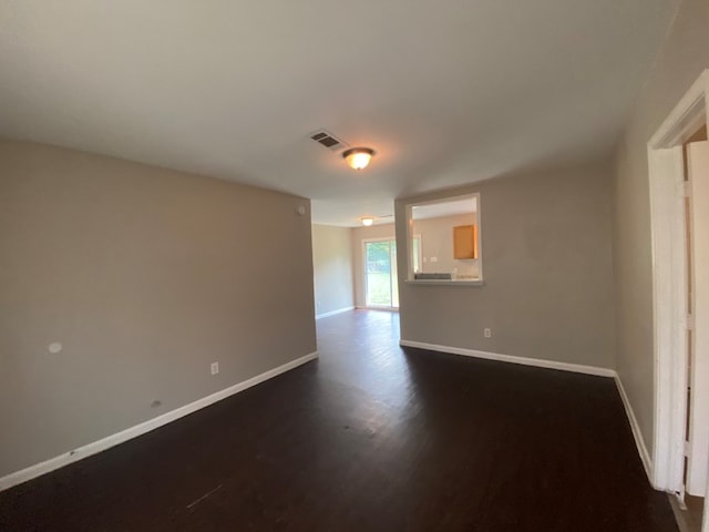 empty room with dark wood-type flooring