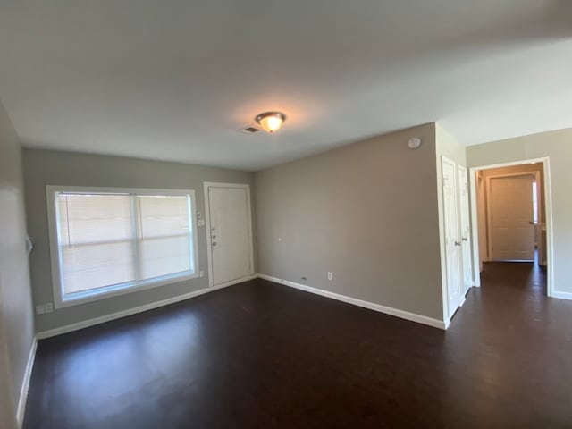 unfurnished room featuring dark wood-type flooring