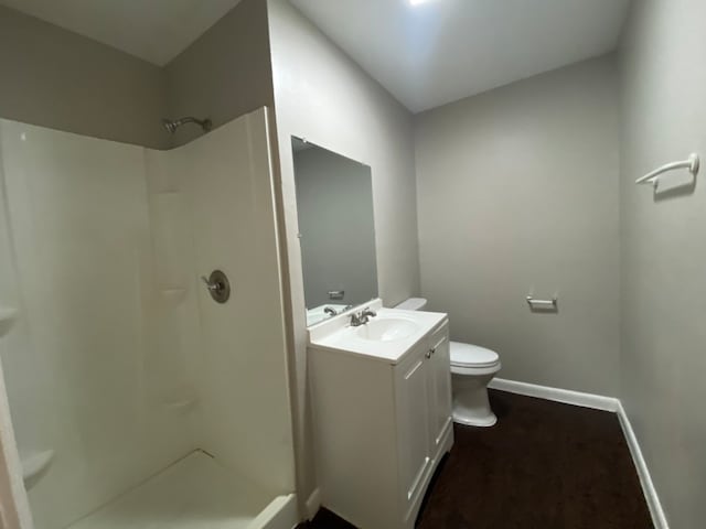 bathroom with walk in shower, vanity, and toilet