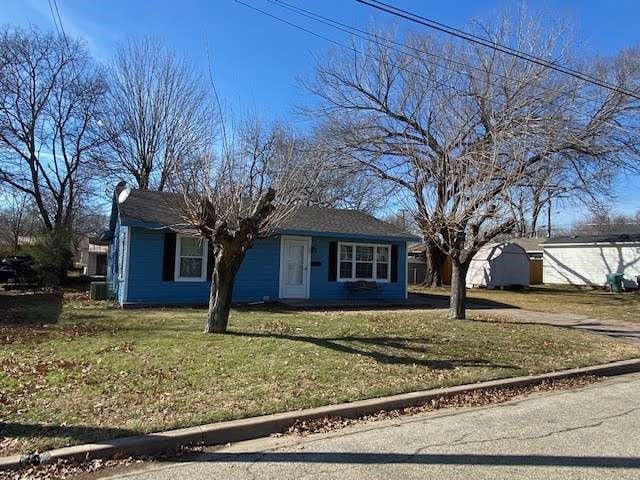 view of front of home with a front yard and a shed