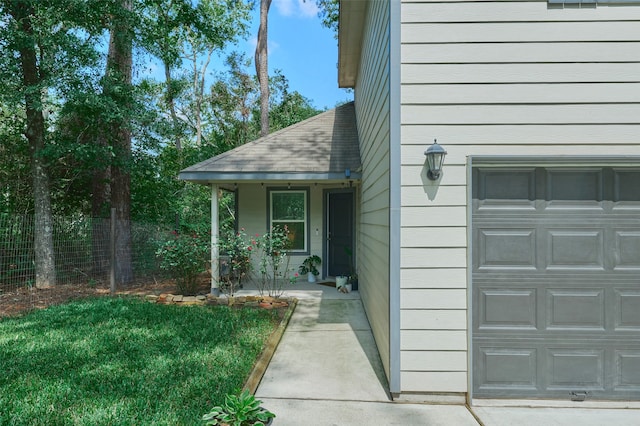 property entrance with a lawn, covered porch, and a garage