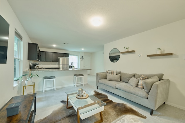 tiled living room featuring sink