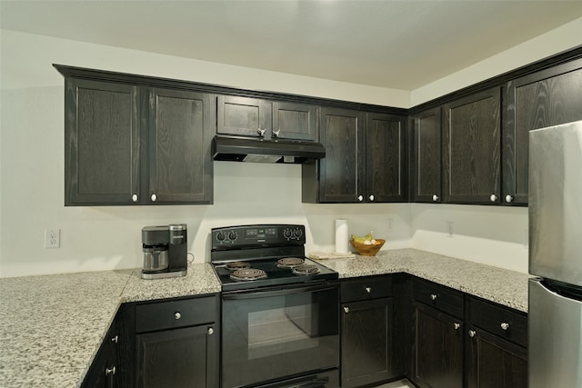 kitchen with light stone countertops, black electric range oven, and stainless steel fridge