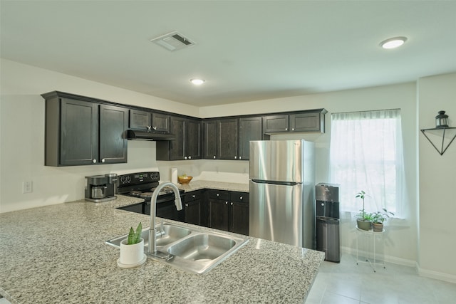 kitchen featuring light stone counters, stainless steel fridge, sink, dark brown cabinets, and black electric range