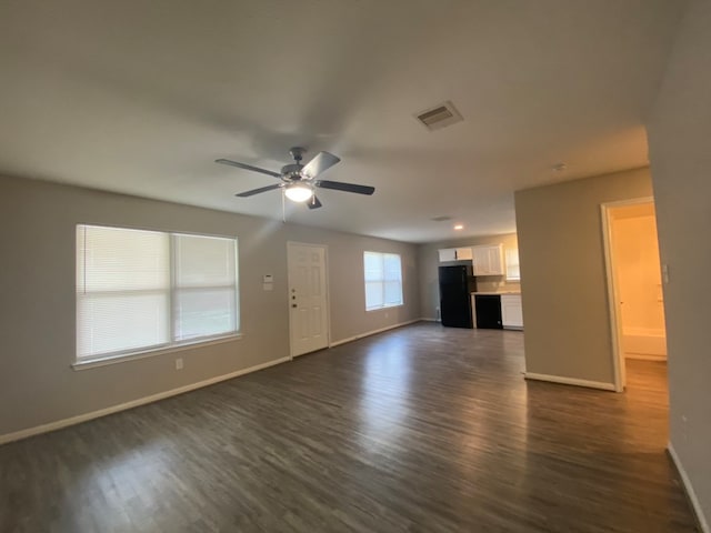 unfurnished living room with ceiling fan and dark wood-type flooring