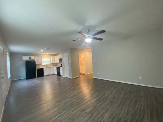 unfurnished living room featuring ceiling fan, dark wood-type flooring, and sink