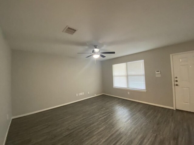 empty room with dark wood-type flooring and ceiling fan