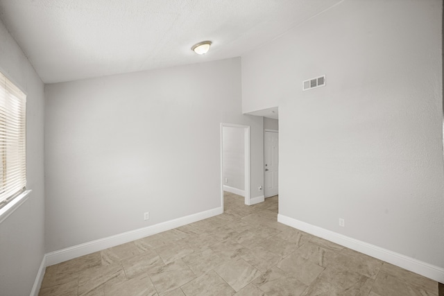 unfurnished room featuring high vaulted ceiling