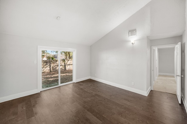 unfurnished living room featuring vaulted ceiling and dark hardwood / wood-style floors