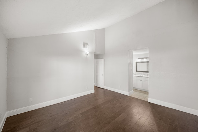 unfurnished living room featuring sink, vaulted ceiling, and light hardwood / wood-style flooring