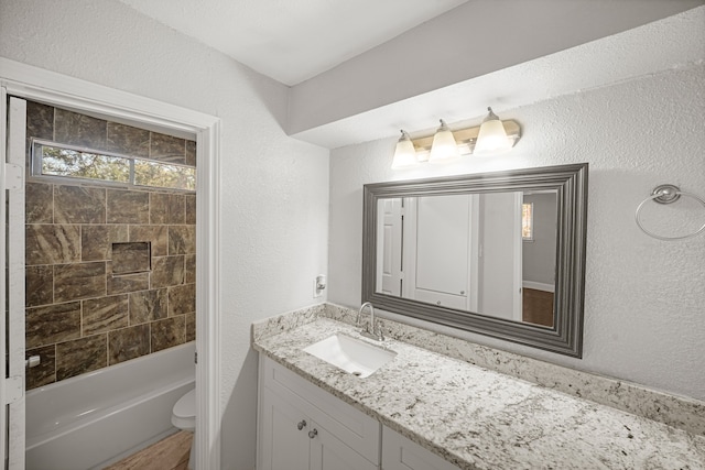 full bathroom featuring vanity, toilet, and tiled shower / bath combo