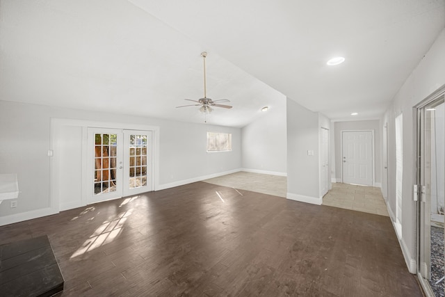 unfurnished living room with dark wood-type flooring, ceiling fan, and french doors