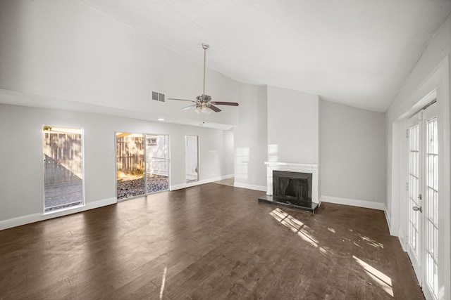 unfurnished living room with ceiling fan, high vaulted ceiling, a wealth of natural light, and dark hardwood / wood-style floors