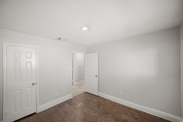 unfurnished room with dark wood-type flooring