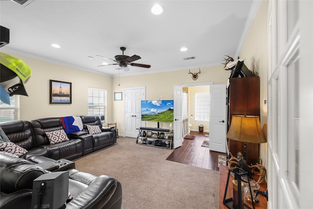 living room with ornamental molding, ceiling fan, and dark wood-type flooring