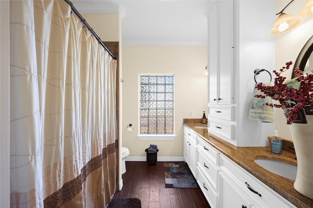 bathroom with wood-type flooring, vanity, toilet, and crown molding