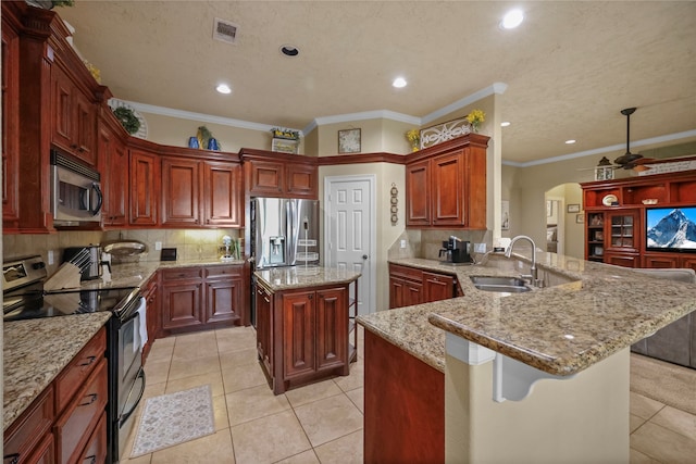 kitchen with a kitchen breakfast bar, decorative backsplash, ornamental molding, kitchen peninsula, and stainless steel appliances