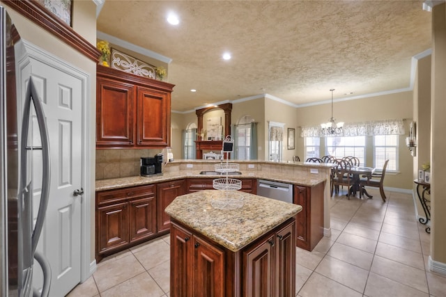 kitchen with kitchen peninsula, a kitchen island, hanging light fixtures, and appliances with stainless steel finishes