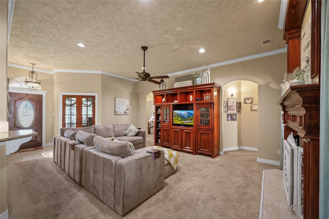 living room with ceiling fan, french doors, crown molding, a textured ceiling, and light carpet